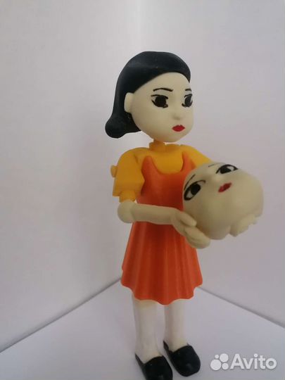 Кукла и игроки из игры в Кальмара