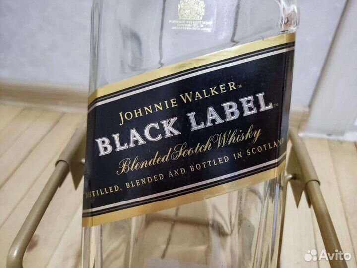 Пустая бутылка виски в подставке качели