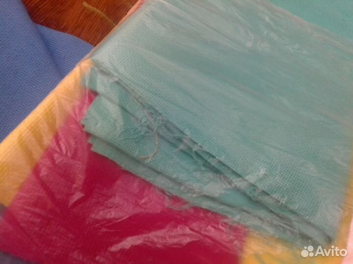 Много ниток и канвы для вышивки