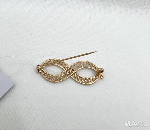 Золотая брошь бесконечность